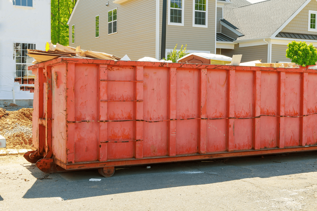 Dumpster in Red Paint at House for Rental